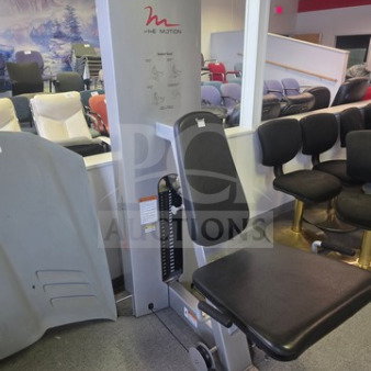 FreeMotion seated exercise machine, features padded seat and backrest, in good condition, with visible weight stack and instructions.