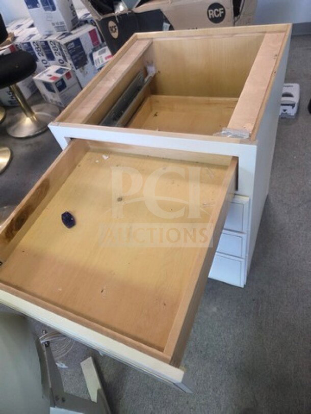 White drawer base cabinet, missing top, three drawers, good condition, visible metal runners, unassembled top drawer.