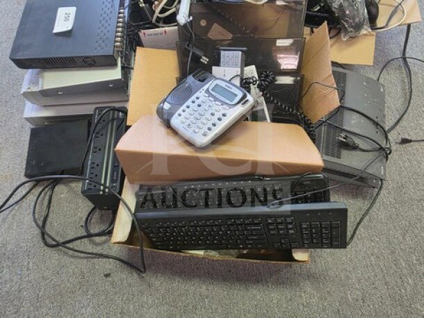 A collection of miscellaneous electronics including keyboards, phones, and network devices; assorted condition.