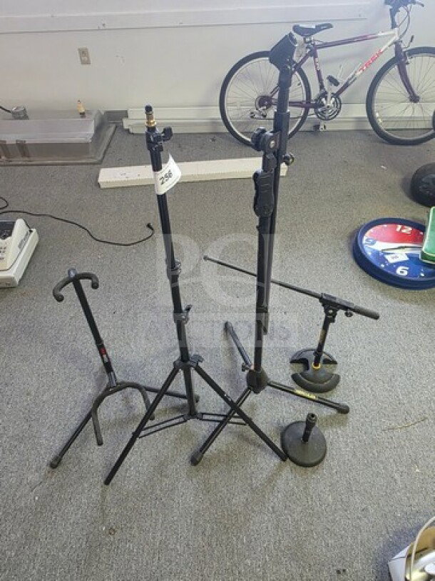 Lot of miscellaneous mic stands and a guitar stand in used condition. Includes various heights and styles.