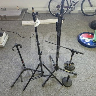 Lot of miscellaneous mic stands and a guitar stand in used condition. Includes various heights and styles.