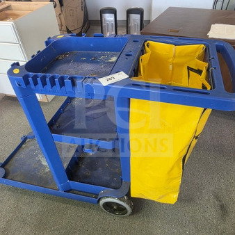 Blue janitor cart with a yellow bag, two wheels, and multiple compartments. Used condition with visible wear. Item number 262.