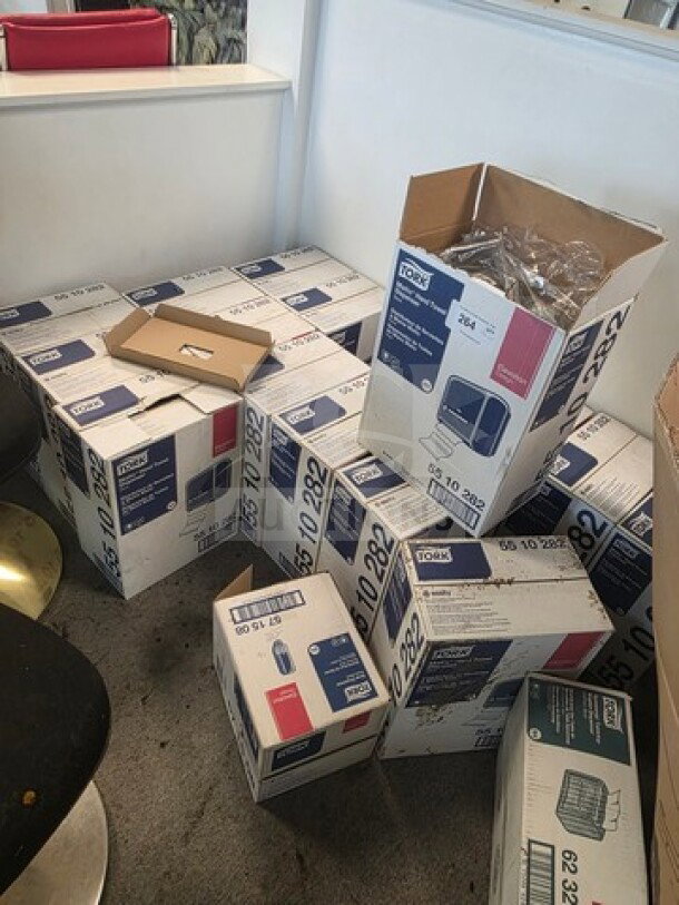 Boxes of Tork hand towel dispensers, various sizes, unopened and partially opened, showing model and product labels.
