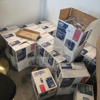Boxes of Tork hand towel dispensers, various sizes, unopened and partially opened, showing model and product labels.