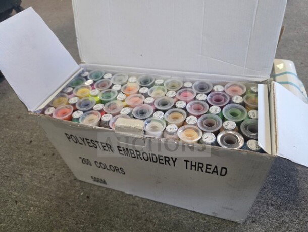 Box of polyester embroidery thread, 260 colors, open to display spools with various hues. Box labeled "Polyester Embroidery Thread."