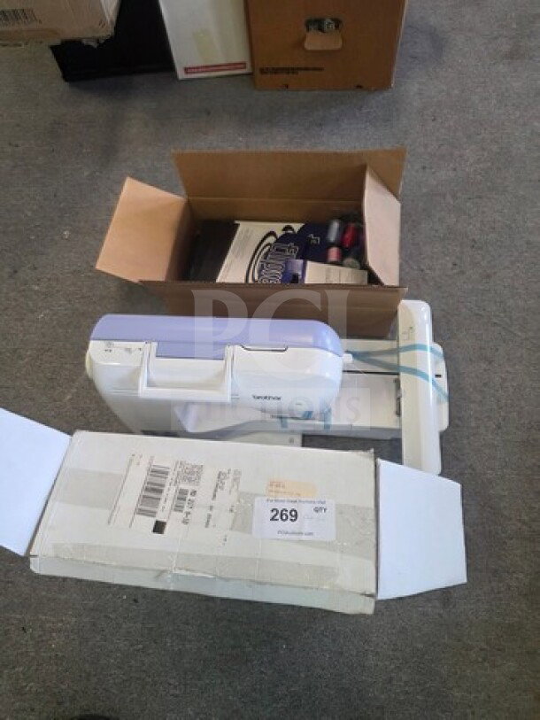 Embroidery machine with Brother logo, includes assorted thread spools, and shipping box marked "269 QTY."