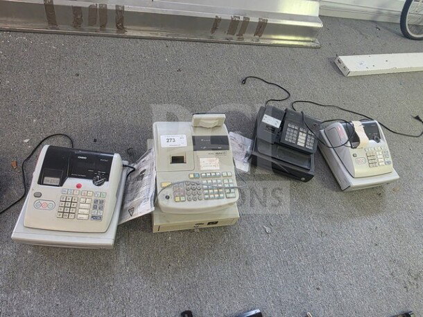 Lot of miscellaneous printing calculators and cash registers on the floor, showing wear. Model numbers visible, including Sharp 1201.
