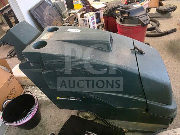 Tennant Nobles SpeedGleam walk-behind floor scrubber, green, visible surface wear, SpeedGleam logo on side.