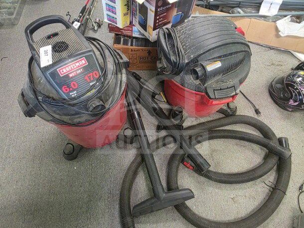 Two Craftsman wet/dry Shop Vacs, model numbers 6.0 and 170, with attachments, red and black, used condition.