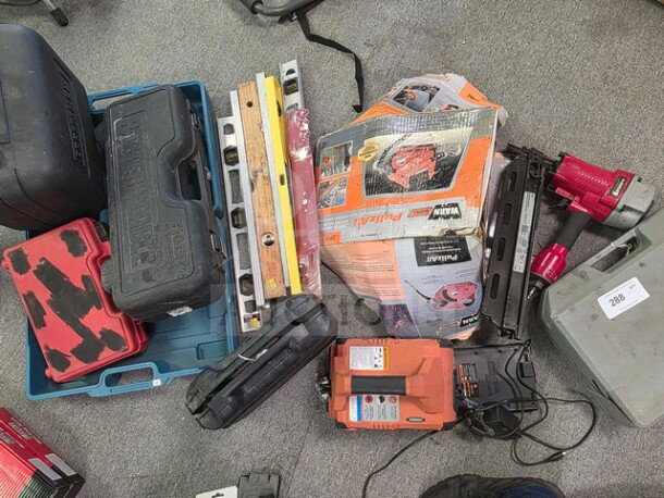 A collection of miscellaneous tools, including tool cases, levels, and power tools, in various used conditions.