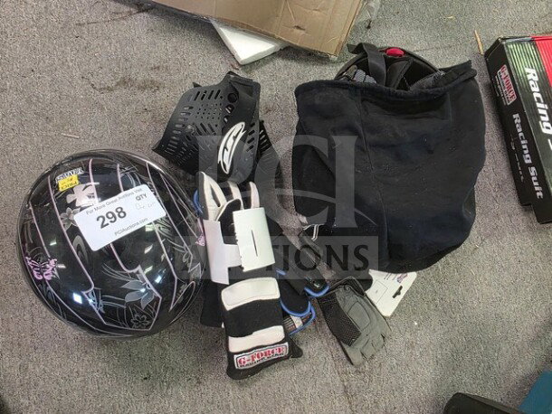 Lot of miscellaneous racing gear including a helmet, protective pads, gloves, and a racing suit. Helmet labeled "298 GQT."