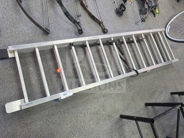 Aluminum loading ramp, lightweight and durable, with 11 rungs. Visible labels include a lot number and safety strap.