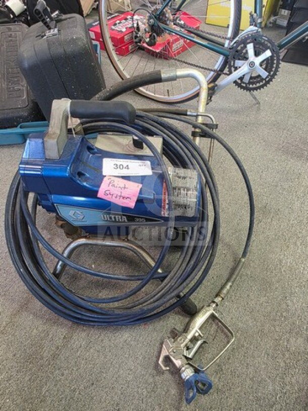 Graco Ultra 395 Paint Sprayer, blue, with hose and spray gun, used condition, "Paint Sprayer" tag attached.