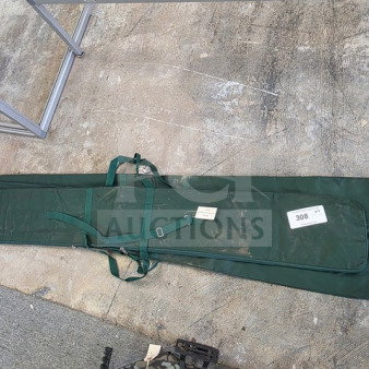 One lot of green Bowflag carrying cases, showing straps and attached tags with number 308, laid on concrete surface.