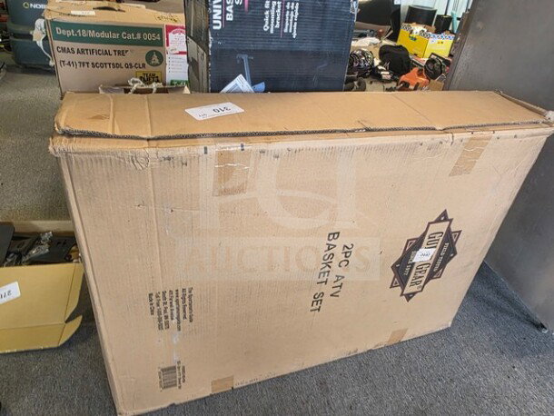"2PC ATV Basket Set in sealed box, brown cardboard packaging with visible product label and various markings."
