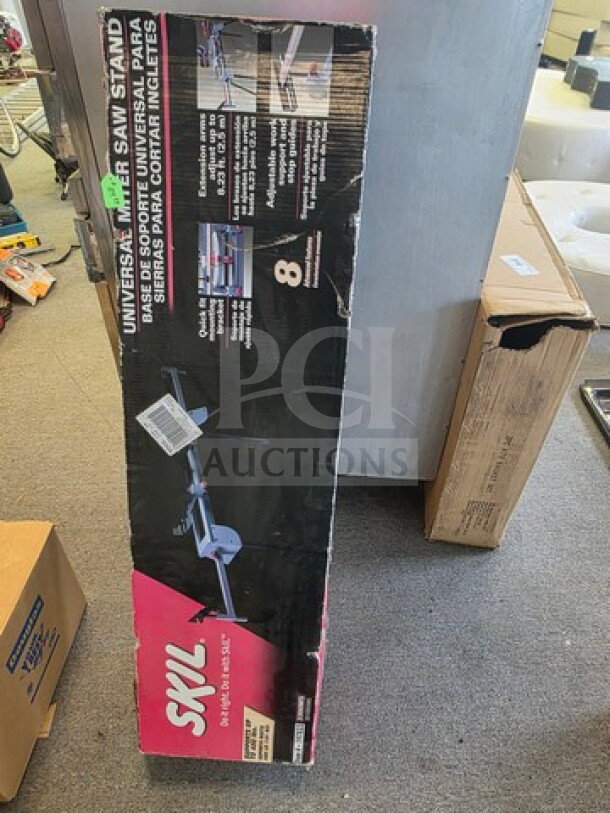 Universal Miter Saw Stand in original SKIL packaging. Key features and specifications are listed on the box. Some wear visible.