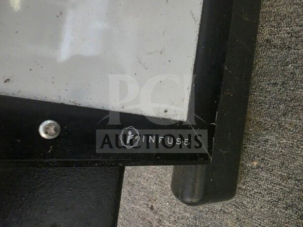 Infuse dry erase board with black frame, visible logo in lower corner, slightly scratched surface, used condition.