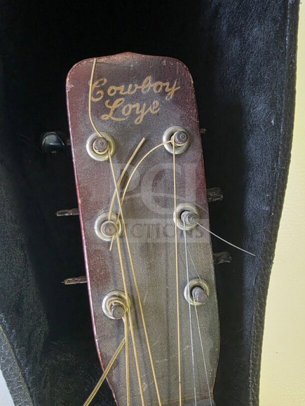Vintage Cowboy Loye parlor guitar headstock, showing brand name and tuning pegs. Finish shows wear. Sold as is.