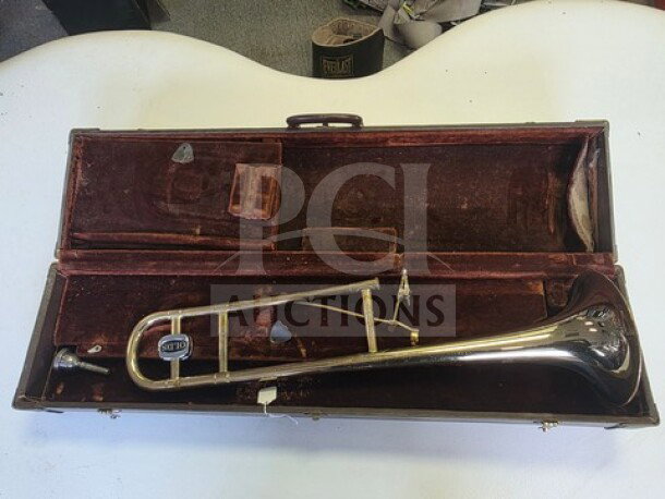Vintage F.E. Olds Ambassador Student Trombone in worn condition, with dented bell, in original velvet-lined case. Sold as is.