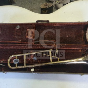 Vintage F.E. Olds Ambassador Student Trombone in worn condition, with dented bell, in original velvet-lined case. Sold as is.