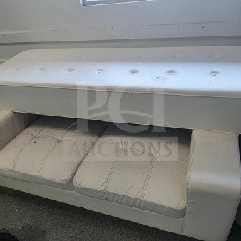 Lot of white club furniture including a tufted bench and sofa. Shows signs of wear. Ideal for club or lounge decor.