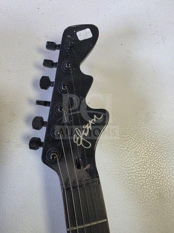 Esteban Midnight Legacy electric guitar headstock, features black finish with signature. Visible price tag labeled "$125". Sold as is.