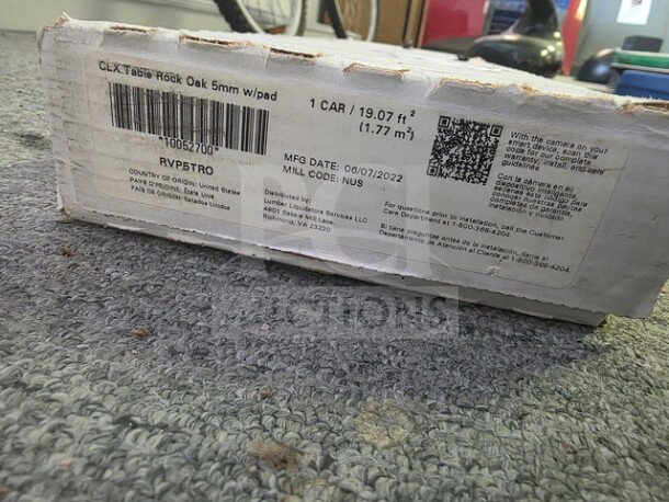 CLX Table Rock Oak 5mm flooring with pad, 19.07 sq ft coverage, manufactured 06/07/2022, visible label with product details.