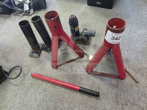 Lot of miscellaneous jack stands in used condition, featuring red and black stands with varying designs. Tag number 342 visible.