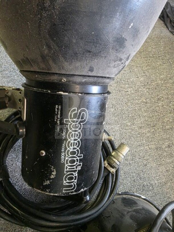 Speedotron Universal Light Unit pair, black, visible wear, "Speedotron" branding, coiled cables, sold as is.