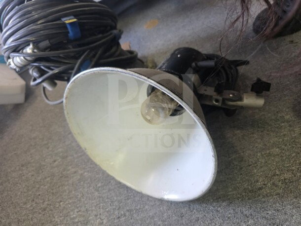 A pair of Speedotron Universal Light Units, black with white reflectors, visible signs of use, cords coiled nearby.