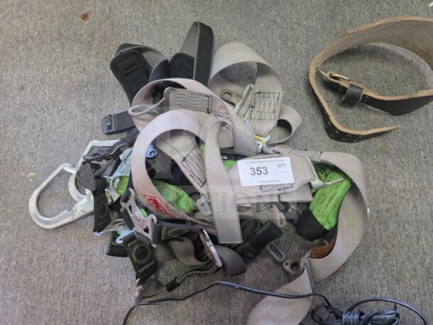 Lot of miscellaneous safety harnesses in various colors and materials, visible carabiners, and a tag labeled "353 GFX".
