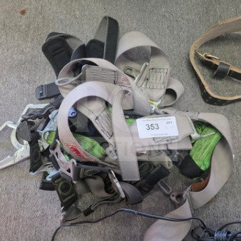 Lot of miscellaneous safety harnesses in various colors and materials, visible carabiners, and a tag labeled "353 GFX".