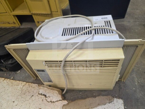 Window air conditioner, off-white, with control panel on the side. Visible wear and power cord attached. Sold as is.