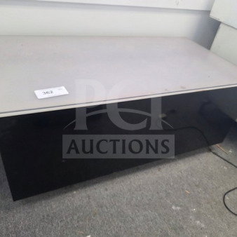 Modern desk with light grey tabletop and black base, minimal wear. Visible tag labeled "362."