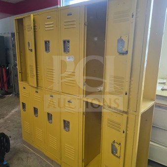 Yellow lockers, multiple units, used condition. Visible wear and minor dents. Ventilation slots and padlock hasps on each door.