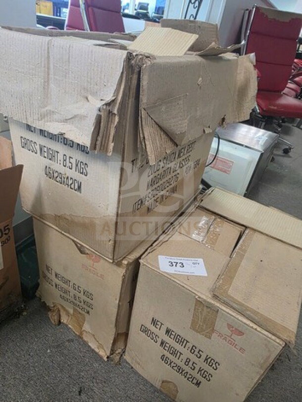 A lot of margarita glasses in damaged cardboard boxes, labeled with weight and dimensions, showing fragile markings.