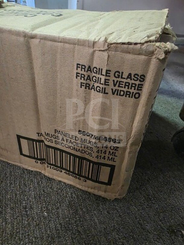 Lot of 14oz glass mugs, boxed. Box marked "Fragile Glass" and "Paneled Mugs, 14 oz." Slight wear on packaging.