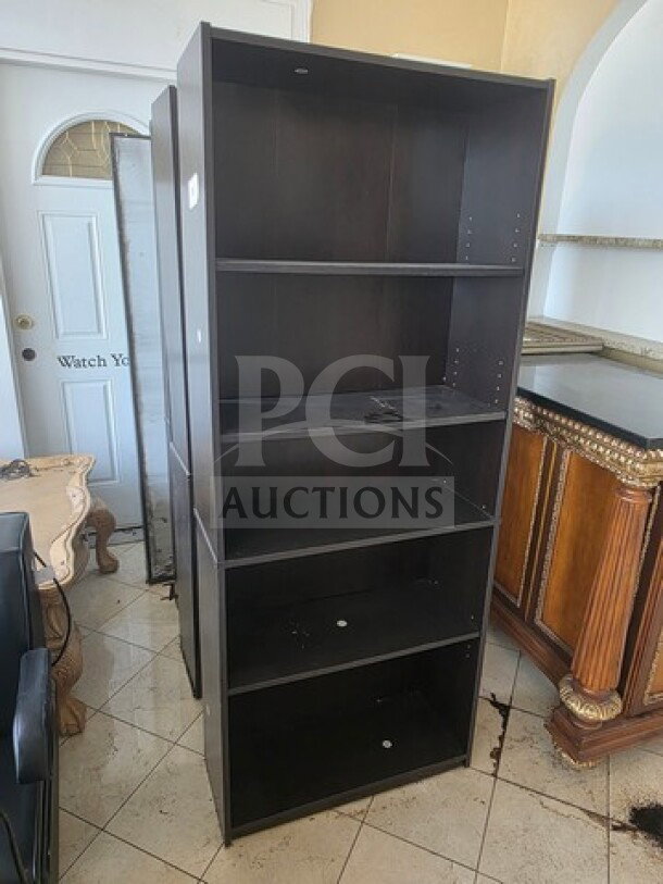 Lot of 3 dark wood bookcases with five shelves each, in good condition. Minimal wear visible, ready for use.