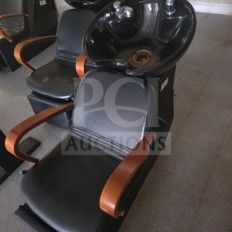 Black shampoo chair backwash unit with round basin, sleek design, and wooden armrests. Good condition, ideal for salons.