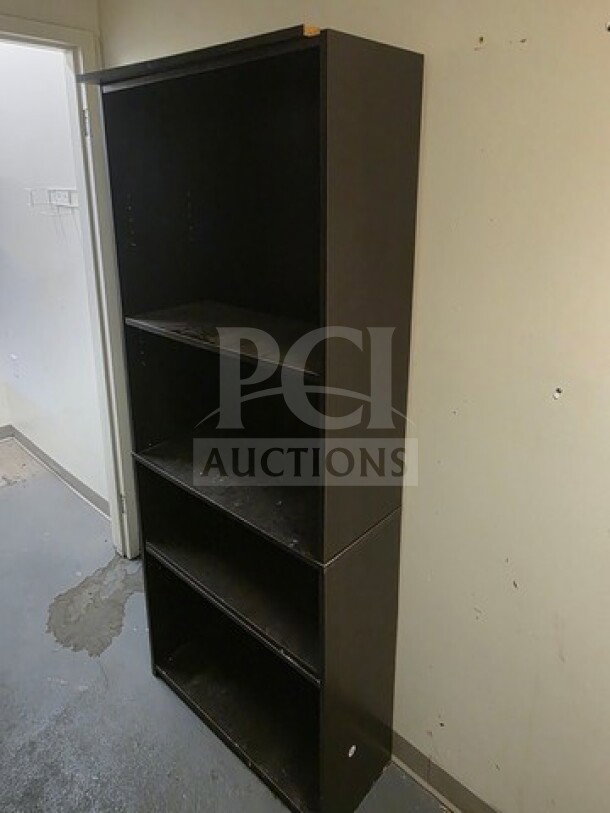 Lot of 2 tall black bookcases, each with four shelves. They appear sturdy but show some wear on surfaces.