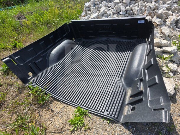 Rugged Liner drop-in plastic bedliner, textured black finish, shown outdoors. Durable construction, excellent condition.