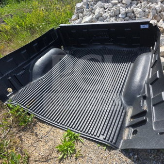 Rugged Liner drop-in plastic bedliner, textured black finish, shown outdoors. Durable construction, excellent condition.