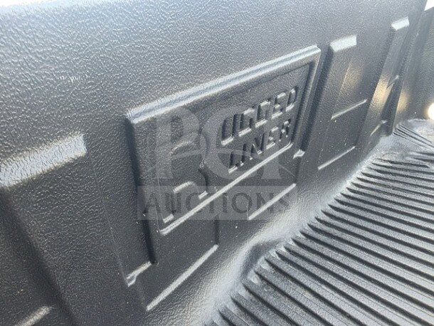 Rugged Liner drop-in plastic bedliner, black, textured finish, logo embossed. Appears in good condition, suitable for truck beds.