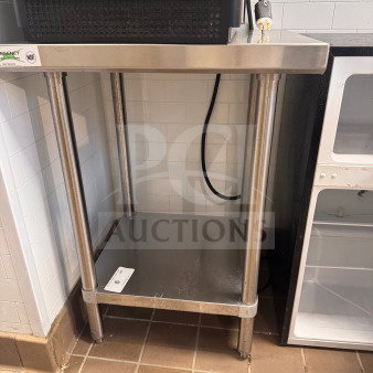 Commercial stainless steel work table with two shelves; NSF certified. Good condition with minor wear, ideal for kitchen use.