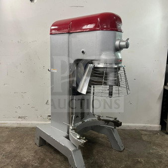 Axis AX-M80 planetary mixer, 80-quart capacity, silver body with red top, visible wear, sturdy base, safety cage present.