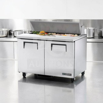 True TSSU-48-12-HC prep table in top-tier condition; 48-inch refrigerated base; 115V; stainless steel; tested operational.