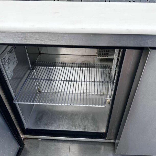 True TSSU-48-12-HC sandwich prep table, top-tier condition, 48-inch, refrigerated base, visible interior shelf, label on door.
