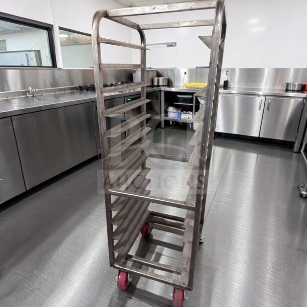 Commercial stainless steel bun pan rack, mobile with red casters, superior condition, ideal for bakery use.