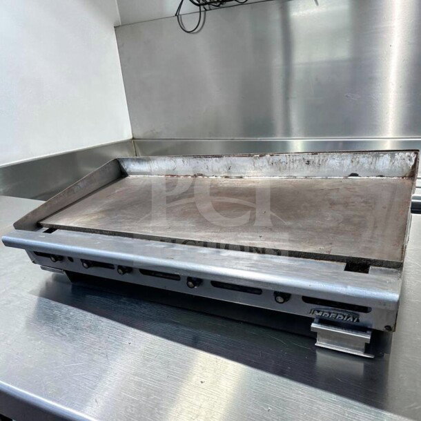 Imperial ITG-60 gas griddle with 1" steel plate, thermostatic controls, and natural gas operation; in superior condition.
