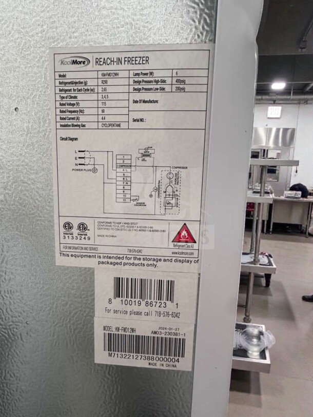 KoolMore KM-FMD12WH commercial reach-in freezer, 12 Cu. Ft., ETL & UL listed, tags show refrigerant info and compliance labels.